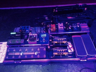 The Beast - mega pedal board player's view, under blue stage lighting